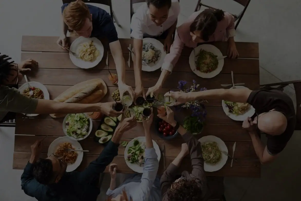 people raising glasses over meal